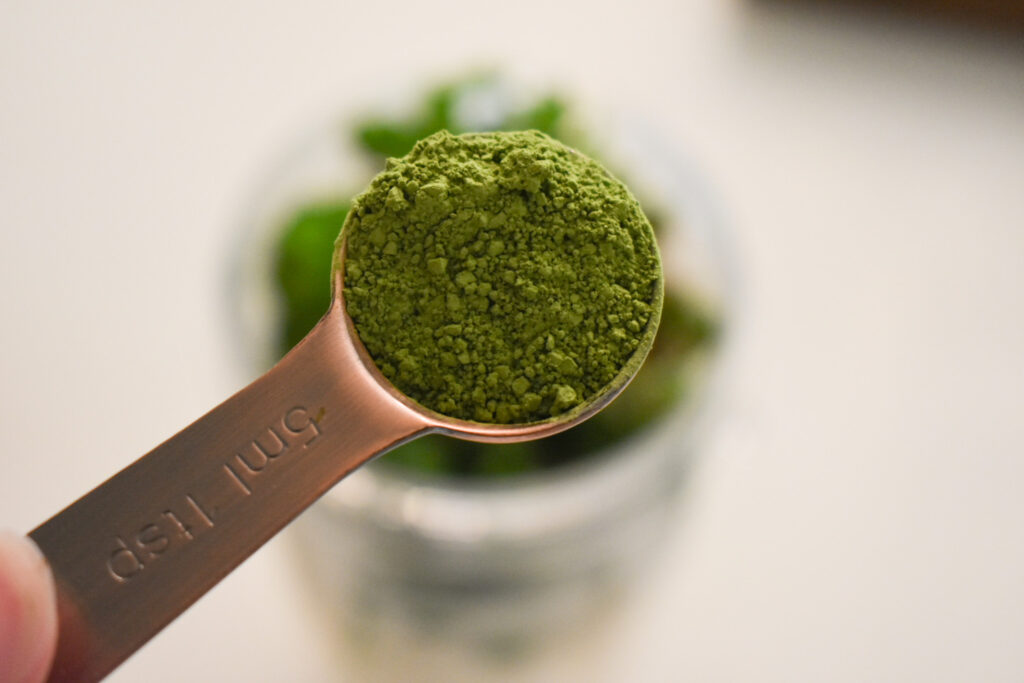 teaspoon of matcha powder over green smoothie