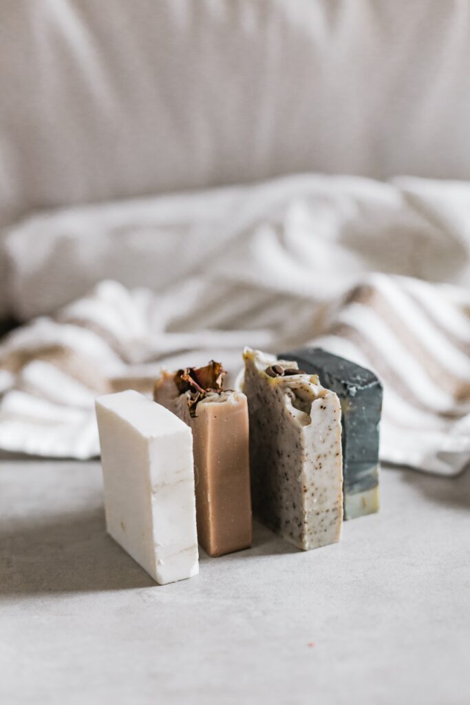 four bars of soap in front of linen background